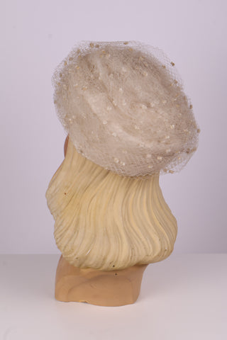 Råhvid pillbox hat med hatteslør og blomst. 1960