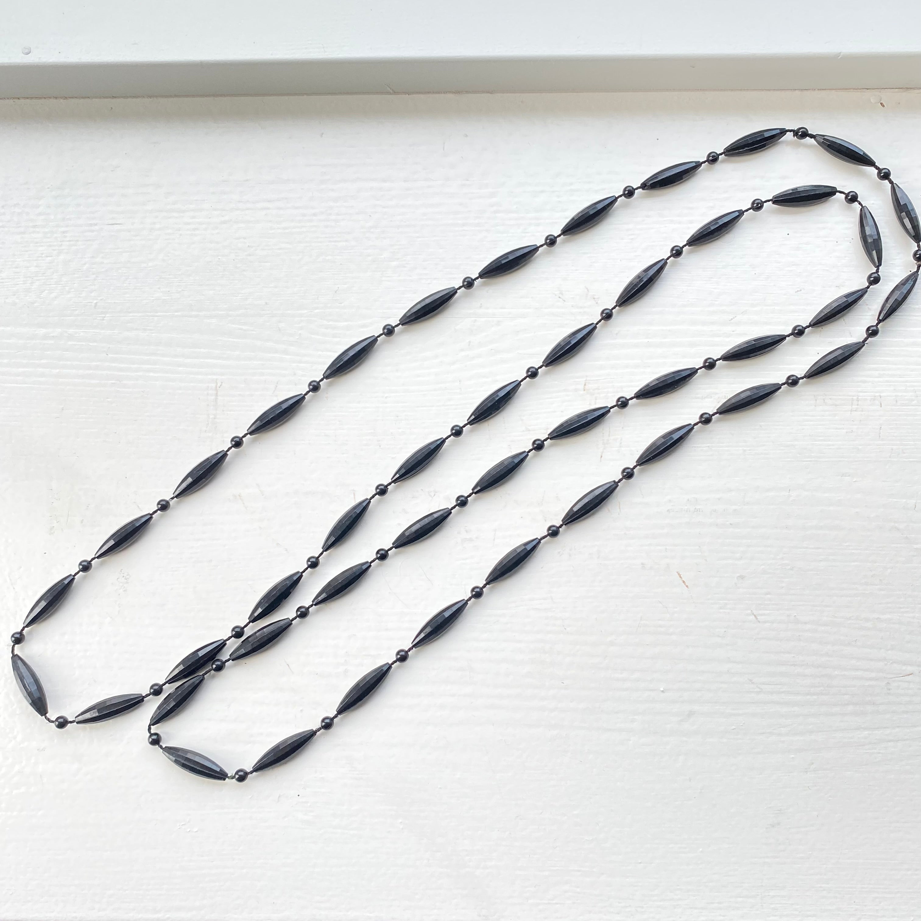 Lang sort halskæde i plast. 1960